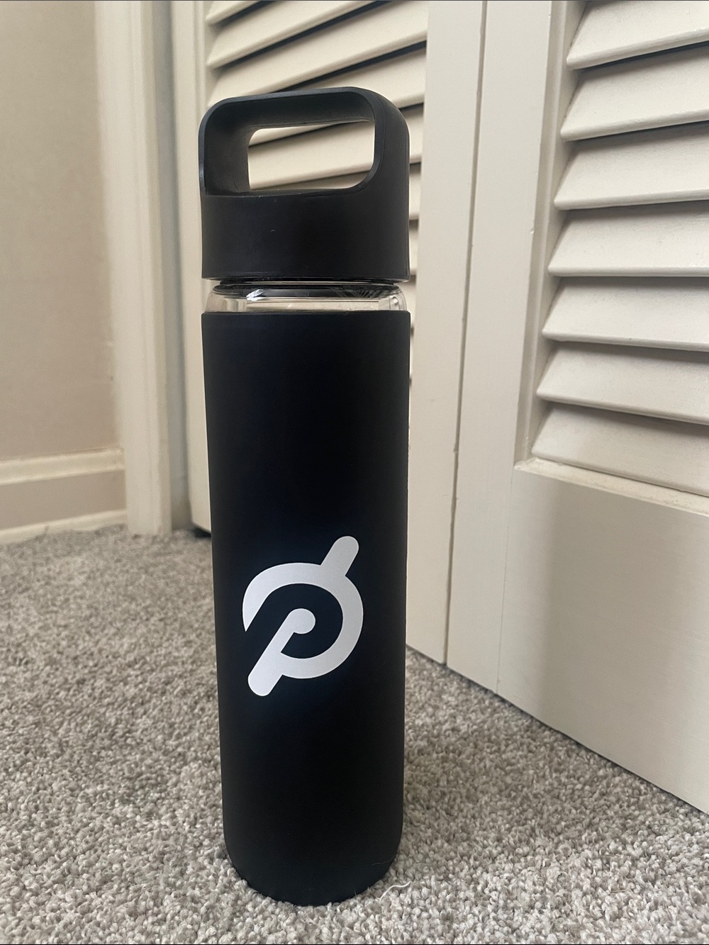 Peloton branded water bottle glass w/ black silicone sleeve screw top